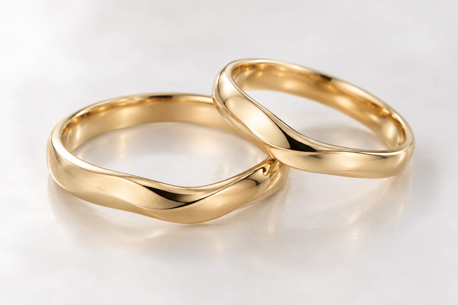 緩やかな曲線を持つシンプルなゴールドの結婚指輪2本
