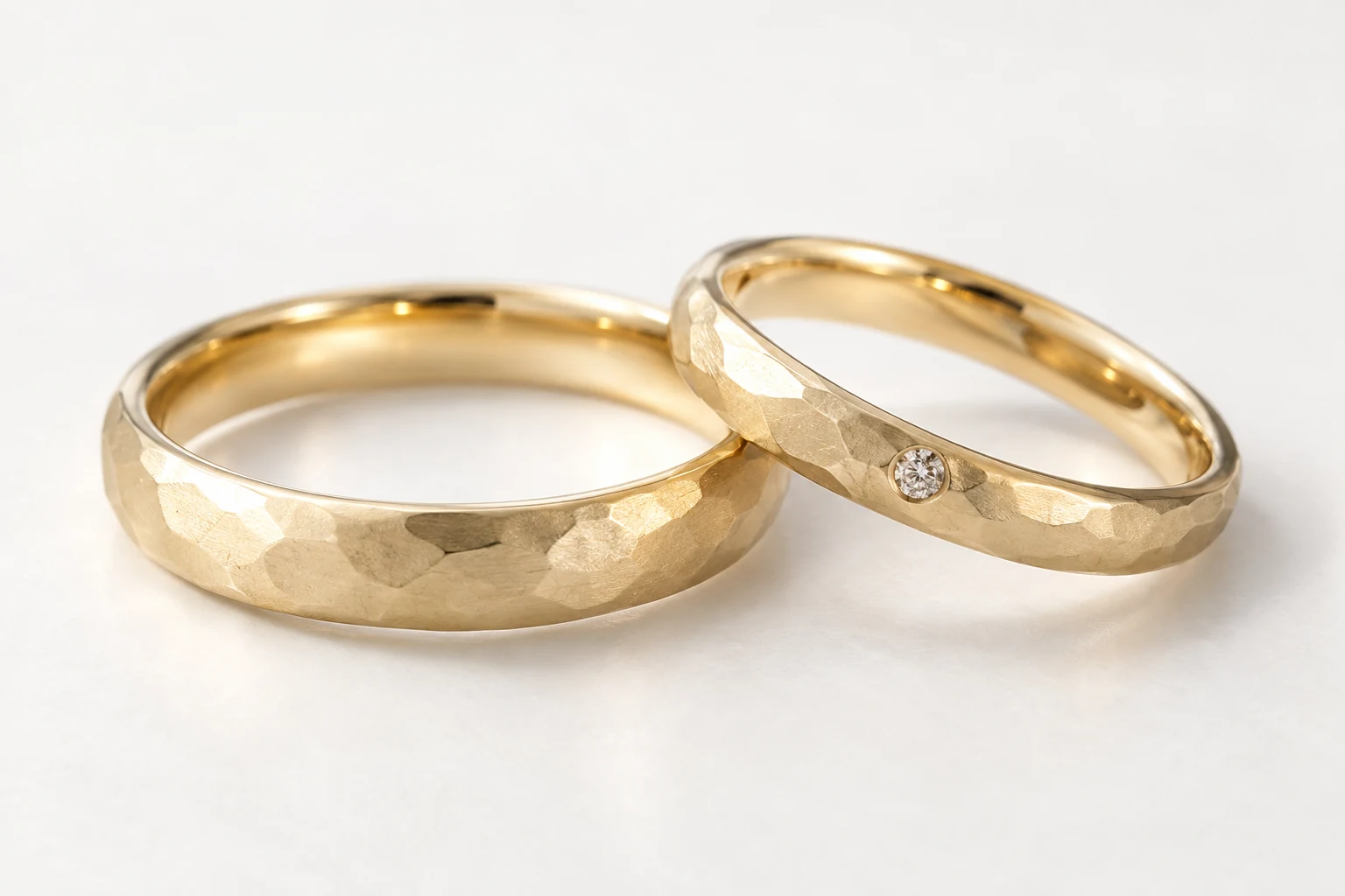 槌目模様をそろえた幅広と細身のゴールドの結婚指輪